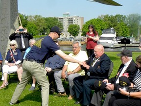 LCdr. Robert Pelton, left, the captain of the HMCS Oriole, hands an Oriole cap to Royal Canadian Navy veteran Bob Murphy during a brief recognition event on Blockhouse Island on Tuesday morning. (RONALD ZAJAC/The Recorder and Times)