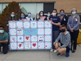 Grade 7 and 8 students at Gregory Drive Public School made a special presentation recently to nurses at Chatham-Kent Health Alliance. Crouching at front are Rudra Patel and Ryan Millington. Behind the sign are Dakota Stover, Stephanie Davidson, clinical education leader, and Charlotte Peco. At back are Lynn Richie, unit clinic leader ICU/PCU, Marcia Walden, manager of professional practice, Erin Dejaegher, occupational health nurse, Jess Casey, professional practice leader, Meredith Whitehead, vice-president of transformation and chief nursing executive, and Lori Marshall, president and CEO. (Trevor Terfloth/Postmedia Network)
