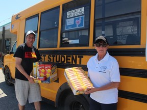 Tim Haskell, left, an organizer of the Fill the Bus campaign to collect food and monetary donations for Chatham Outreach for Hunger, is seen here with Outreach for Hunger executive director Brenda LeClair with some donations collected on Saturday. PHOTO Ellwood Shreve/Chatham Daily News.