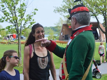 From left, Grace Rondeau and Darquies Menard listening to a re-enactor on Saturday May 21, 2022 in Cornwall, Ont. Shawna O'Neill/Cornwall Standard-Freeholder/Postmedia Network