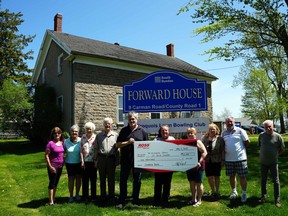 Handout/Cornwall Standard-Freeholder/Postmedia Network
Ross Video chief manufacturing and services officer Jeff Poabst, to the left side of cheque, and founder John Ross, present a $10,000 donation from the company to the Historical Society of South Dundas, to support its work in preserving the historic Forward House in Iroquois.