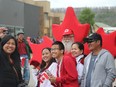 People grab a photo with a man dressed as a maple leaf during the Canada Day Parade in downtown Fort McMurray on Monday, July 1, 2019. Laura Beamish/Fort McMurray Today/Postmedia Network ORG XMIT: POS1907061617482755
