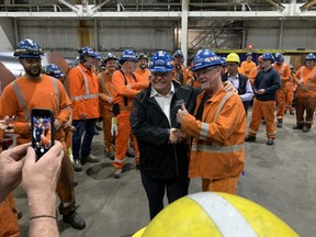 Ontario Premier Doug Ford poses for photos with steelworkers at Steco in Hamilton on Wednesday, May 18, 2022.