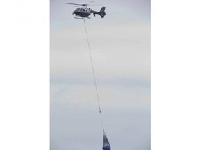 An OPP helicopter lifts a refrigerator from the beach below a Lake Erie bluff east of Port Burwell on Tuesday, May 7, 2019. Earlier, the helicopter lifted a body from the beach off Lakeshore Line east of Stafford Road.  Derek Ruttan/The London Free Press