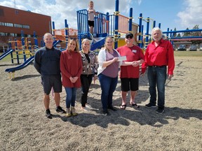 The Kinsmen Club presented a cheque of $1,000 on Apr. 29 to the Spitzee Playground committee to help with funding for the new playground. From left to right – Spitzee Vice-Principal Bill Holmes, Spitzee Playground committee’s Tricia Swallow, Tiegan Jamison, and Alison Brown, Kinsmen Bob Goll and Bruce Olmstead and on the playground is Bextyn Jamison.