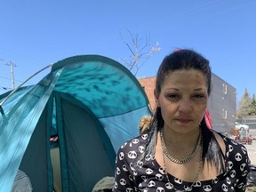 Jennifer Nolan Kennedy, an unhoused resident at Belle Park, stands in front of her tent on Sunday.