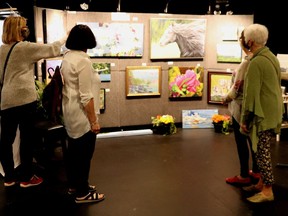 People stopped to admire Kitty Kelly's art at the Before the Summer art show and sale held at the Firehall Theatre in Gananoque on May 7 and 8.  
Lorraine Payette/for Postmedia Network