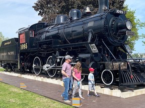 A family takes a close look at the Spirit of Sir John A. engine in Confederation Park on Monday, May 31, 2022, during Tourism Awareness Week in Kingston.