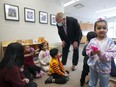 Ontario Premier Doug Ford, centre, visits a daycare centre after reaching an agreement with the federal government on a $10-a-day child-care program deal in Brampton, Ont., on Monday, March 28, 2022. When Ontario signed the deal with the federal government in late March, it said parents would start seeing rebates in May, but with the program still in its early stages, the sector says that's unlikely to happen.