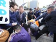 Police remove protesters who were blocking PC Leader Doug Ford's arrival outside the Ontario election leaders' debate in Toronto on Monday, May 16, 2022.