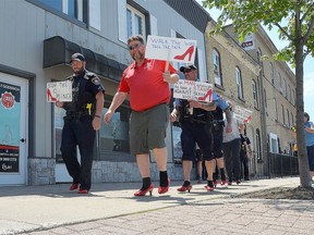 Saugeen Shores Police Service Chief Kevin Zettel, left, and Rob Searson of the Lucknow Kinsmen lead the Walk A Mile in Her Shoes event along Goderich Street in Port Elgin in May 2022.