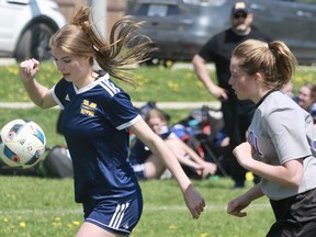 St. Mike’s Nicole Simmons keeps her eyes on the ball while an F.E. Madill player stays in pursuit during the Huron-Perth senior girls’ soccer final Thursday afternoon. St. Mike’s won 3-0.