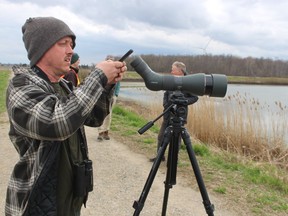 Brandon Aho, a birder from Michigan, set up a scope at the Thedford sewage lagoons Monday.