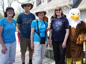 Mary Martin with Lambton Wildlife, left, John Cooke with the Sarnia Bird Team, Brenda Lorenz with Friends of Canatara Park, Lynn Eves with the Bluewater Centre for Raptor Rehabilitation and Debbie Chapman dressed as the centre's eagle mascot pose for a photo during a World Migratory Bird Day event the groups participated in at Canatara Park Saturday. (Tyler Kula/ The Observer)