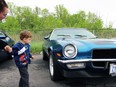 Sterling Hanna, 3, from Sarnia holds mom Lucie's hand while checking out his uncle's Chevrolet Camaro during the Sarnia Street Cruisers event at Preferred Towing on Sunday, May 22, in Sarnia, Ont. Terry Bridge/Sarnia Observer/Postmedia Network