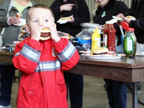Jack Corsaut, 4, from Sarnia takes a big bite of his burger during the Sarnia Street Cruisers event at Preferred Towing on Sunday, May 22, 2022 in Sarnia, Ont.  Terry Bridge/Sarnia Observer/Postmedia Network