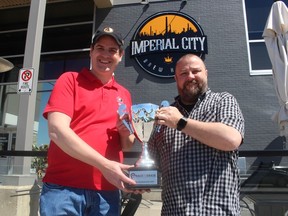 Organizers, from left, Scott McKay and Rich Bouchard hold the Race to Erase trophy Saturday.  The annual community event and fundraiser returned this year to Sarnia after taking a two-year break because of pandemic restrictions.