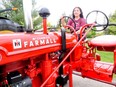 Joyce Fox, a Holy Trinity Catholic High School student, sits on her family's Farmall during the school's Car, Truck and Tractor Show on Friday. CHRIS ABBOTT