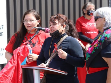 Juliette Wemigwans, middle, is comforted by Autumn Lewis, left, and Nookimis Martina Osawamick, as she addresses a crowd at a ceremony at the unveiling of the Red Dress Art Reveal at the NÕSwakamok Native Friendship Centre in Sudbury, Ont. on Thursday May 5, 2022. The event was held on the National Day of Awareness for Missing and Murdered Indigenous Women, Girls and Two-Spirit people. The art was created by Kathryn Corbiere, of One Kwe Modern Fabrications, and commissioned through the Looking Ahead to Build the Spirit of Our Women ÐLearning to Live Free from Violence project in collaboration with the NÕSwakamok Native Friendship Centre. John Lappa/Sudbury Star/Postmedia Network