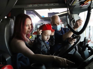Firefighter Mark Muldoon shows Jackson Twain, 4, and Jackson's mom, Kayla, the inside of a fire truck at the downtown fire station in Sudbury, Ont. on Wednesday May 11, 2022. John Lappa/Sudbury Star/Postmedia Network