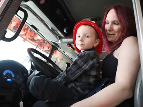 Jackson Twain, 4, and his mom, Kayla, sit inside the cab of a fire truck at the downtown fire station on May 11.