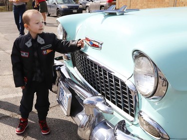 Four-year-old Jackson Twain checks out a classic car in Sudbury, Ont. on Wednesday May 11, 2022. Jackson took part in a classic car parade, and he visited the Lorne Street Dairy Queen where he learned to make ice cream cones. He then visited members of the Greater Sudbury Police and rode in a fire truck while visiting the downtown fire station. John Lappa/Sudbury Star/Postmedia Network