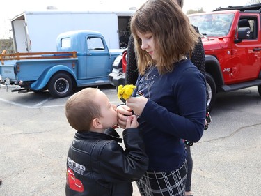 Jackson Twain, 4, kisses his sister, Izebella, 9, on her hand while checking out classic cars in Sudbury, Ont. on Wednesday May 11, 2022. John Lappa/Sudbury Star/Postmedia Network