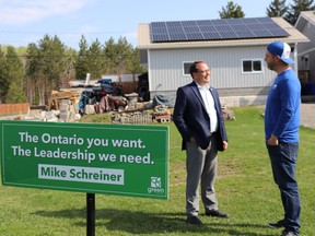 Solar Associates owner Steve Deforge (right) discusses Northern Ontario's solar panel industry with Schreiner following the announcement of the Greens' retrofit grant proposal. Mia Jensen/Local Journalism Initiative