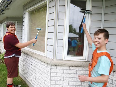 Raphael Delparte, 13, left, and Tru Eng, 13, clean windows at The Walford Sudbury on Thursday May 19, 2022. Grade 8 students from Ecole St-Denis visited the retirement home in Sudbury, Ont. to put their Pay it Forward project into practice by giving back to the local community and seniors. During their visit, students cleaned windows, doors and siding, swept the grounds, repaired flower beds, painted benches and cleaned up the property. John Lappa/Sudbury Star/Postmedia Network