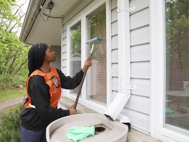 Jasmine Mwiza, 14, cleans a window at The Walford Sudbury on Thursday May 19, 2022. Grade 8 students from Ecole St-Denis visited the retirement home in Sudbury, Ont. to put their Pay it Forward project into practice by giving back to the local community and seniors. During their visit, students cleaned windows, doors and siding, swept the grounds, repaired flower beds, painted benches and cleaned up the property. John Lappa/Sudbury Star/Postmedia Network