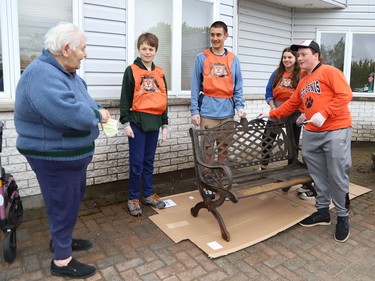 Resident Jeannine Landriault looks on as students prepare to paint a bench at The Walford Sudbury on Thursday May 19, 2022. Grade 8 students from Ecole St-Denis visited the retirement home in Sudbury, Ont. to put their Pay it Forward project into practice by giving back to the local community and seniors. During their visit, students cleaned windows, doors and siding, swept the grounds, repaired flower beds, painted benches and cleaned up the property. John Lappa/Sudbury Star/Postmedia Network