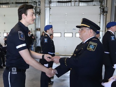 Joseph Nicholls, right, general manager of Community Safety for Greater Sudbury, presents new paramedic Stephane Belec with epaulettes during a ceremony marking national Paramedic Week at the Lionel E. Lalonde Centre in Azilda, Ont. on Tuesday May 24, 2022. John Lappa/Sudbury Star/Postmedia Network