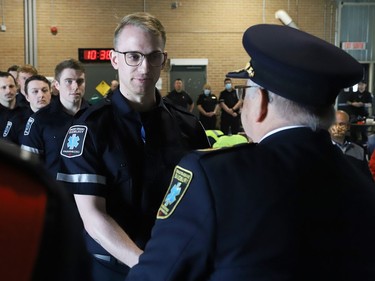 Joseph Nicholls, right, general manager of Community Safety for Greater Sudbury, presents new paramedic Nick Cuomo with epaulettes during a ceremony marking national Paramedic Week at the Lionel E. Lalonde Centre in Azilda, Ont. on Tuesday May 24, 2022. John Lappa/Sudbury Star/Postmedia Network