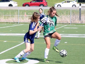 Sophie Huneault (19) of the Notre Dame Alouettes battles Kiara Levac (5) of the l'Horizon Aigles during the SDSSAA Open Girls Premier soccer final at James Jerome Sports Complex in Sudbury, Ontario on Tuesday, May 24, 2022.