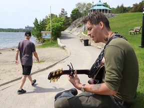 Wolfgang, a musician and busker, plays a tune as geese and people pass by at Bell Park in Sudbury, Ont. on Monday May 30, 2022. John Lappa/Sudbury Star/Postmedia Network