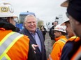 Ontario Premier Doug Ford greets workers at a construction site, before speaking to the media, as he starts his re-election campaign, in Brampton, Ont. on Wednesday, May 4, 2022.