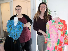 Sombra Museum curator Kailyn Shepley and student curatorial assistant Julie Grant hold up two dresses that will be a part of the museum's new fashion exhibition on the second floor of the Bury House.  Carl Hnatyshyn/Sarnia This Week
