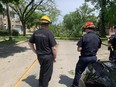 Brantford firefighters keep watch on a downed tree on Darling Street near Drummond Street following a Saturday afternoon storm that ripped through Brantford and the surrounding area.
