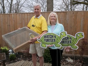 John and Jan Everett from Long Point hold the Long Point Biosphere 'Watch 4 Turtles' signs and a nesting box. This year they have 100 signs and 30 protective cages to distribute in the Norfolk area. CHRIS ABBOTT