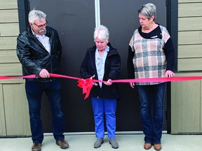 Beryl Burke, who's on the a Carmangay Community Centre Assocation's board, cuts the ribbon April 23 to officially open the new Carmangay Community Centre. To the left is Doug Fraser, who's also on the association's board and is a Village of Carmangay councillor, and to the right is Laurie Lyckman, a Vulcan County councillor. STEPHEN TIPPER