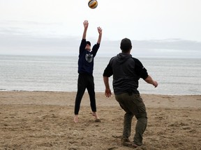 Ryder Mighton (left), his father Ben Mighton and uncle Adam Mighton (out of frame) enjoy some volleyball on Sauble Beach Saturday afternoon. The family from Hanover has a family cottage in the area and made the best of the overcast day on the unofficial kick-off to summer May long weekend. Greg Cowan/The Sun Times