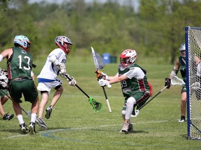 Jacob Lundgren is stopped in tight as the St. Mary's Mustangs take on the Holy Cross Canes Monday afternoon. The Mustangs played host Monday for the opening day of the OFSAA A/A varsity boys field lacrosse championship at the Kiwanis Soccer Complex in Owen Sound. Greg Cowan/The Sun Times