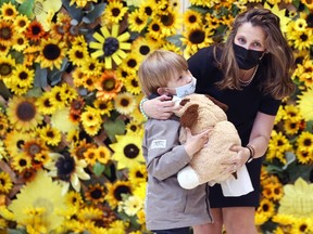 Deputy prime minister Chyrstia Freeland gives a toy to a boy as the first federal charter flight of Ukrainian refugees arrived at Winnipeg International Airport on Monday, May 23, 2022.