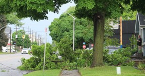 Renne Hamm, right, recalls hearing a loud cracking noise and bang before looking out of the front door of her Grand Avenue East home in Chatham to see a large section of a tree in her front yard, which also took down a power line.  (Ellwood Shreve/Chatham Daily News)