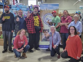 Mick Foley seen wearing his iconic red flannel shirt poses alongside staff members and volunteers from the Gleaners Food Bank. Submitted.