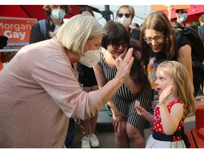Ontario NDP leader Andrea Horwath gets a high five from young Lilly Zimmerly-Hymers during a stop at Ottawa's Beachconers Microcreamery in Britannia earlier this week.