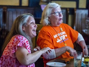 Bay of Quinte NDP candidate Alison Kelly, left, reacts alongside a supporter as polling numbers begin to roll in on Thursday night during her election night party at the Beaufort Pub in Belleville, Ontario. ALEX FILIPE