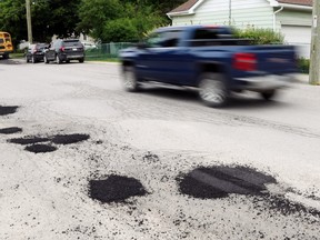 A truck passes fresh patches on Barker Street Monday in Picton. Voters in CAA's Worst Roads contest chose the street as the worst in eastern Ontario and the third-worst in the province.