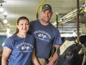 Selena and Phil Prinzhaven, owners of Prinzhaven farms, stand beside one of their dairy cows on their farm in Bloomfield, Ontario. ALEX FILIPE