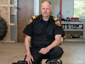 Fire Chief Steve Hemsworth does a side-by side comparison between the fire department’s  new battery powered chain saw (left) and  the older gas-powered model.  The new saw’s lighter weight and its easy stop-start features will be an advantage during calls to structure fires. Marguerite LaHaye